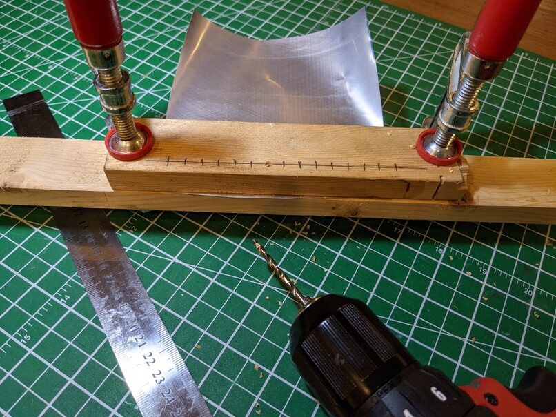 Clamp the aluminum foil between 2 pieces of wood.